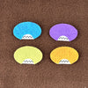 Four oval shaped faces in different colors and pointed teeth sit atop a brown fleece background.