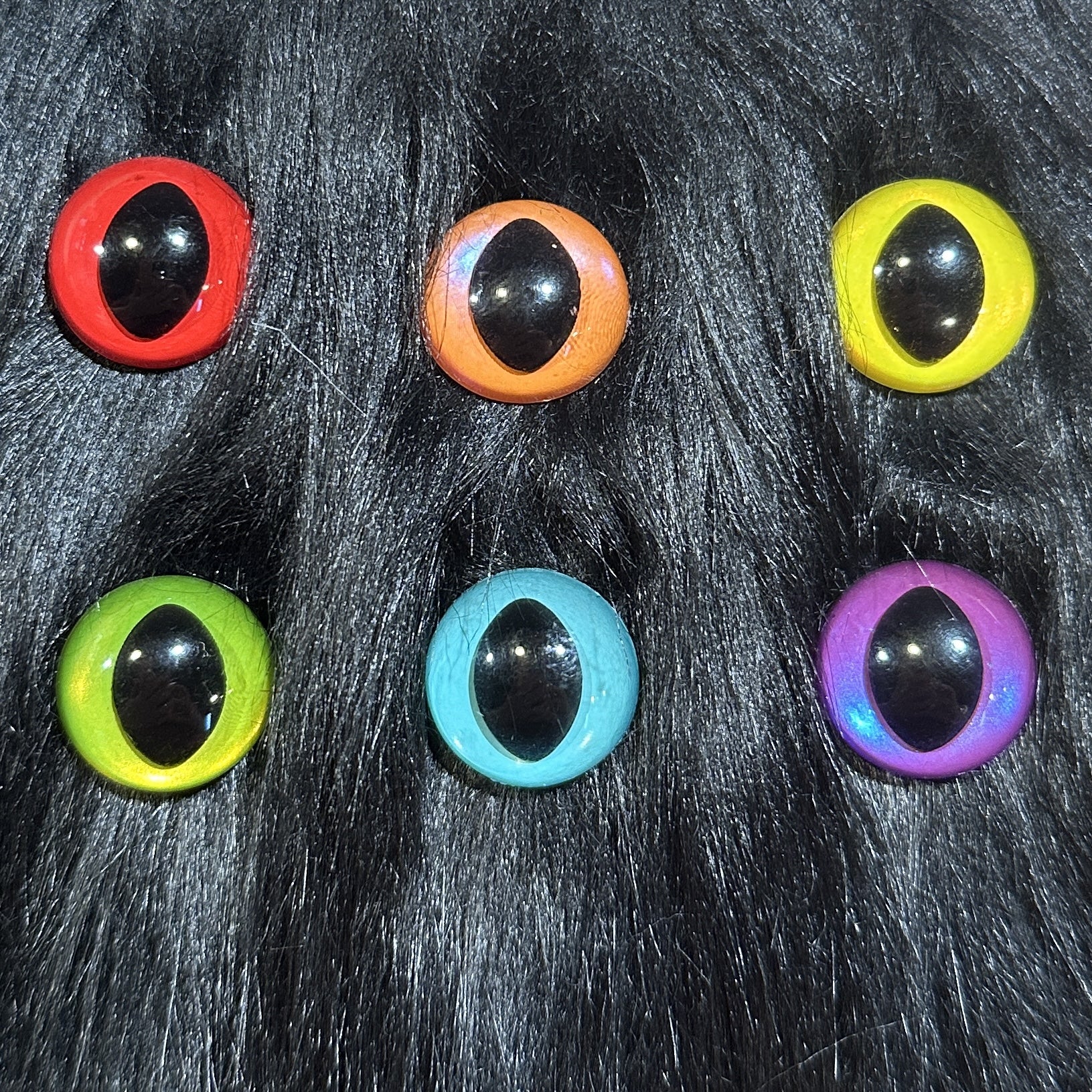 Slit pupil safety eyes in six colors lay atop black faux fur.