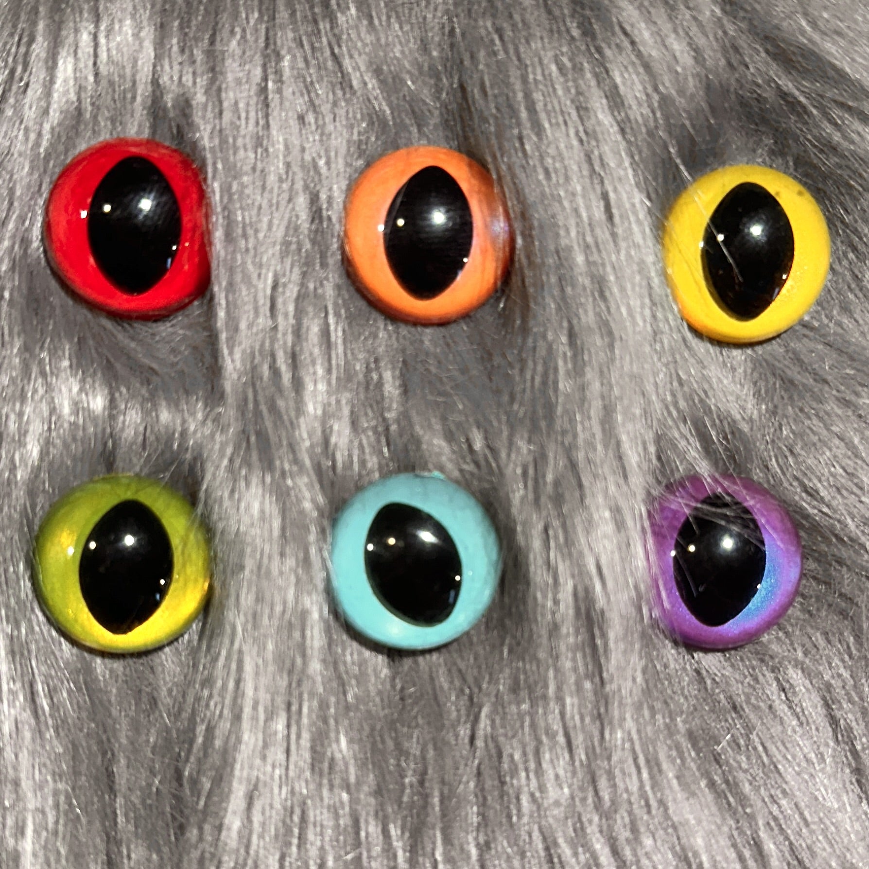 Slit pupil safety eyes in six colors lay atop grey faux fur.