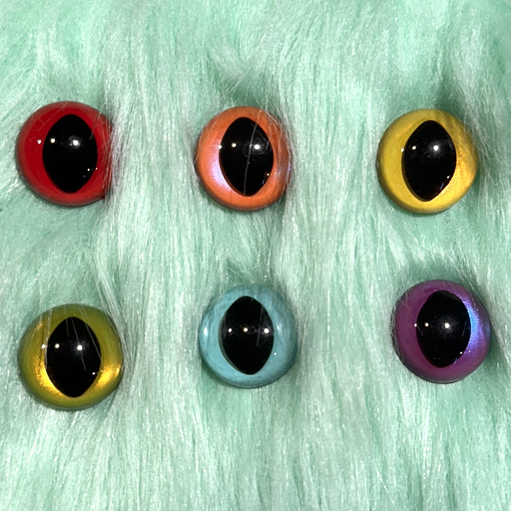 Slit pupil safety eyes in six colors lay atop mint faux fur.