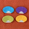 Four oval shaped faces in different colors and pointed teeth sit atop an orange fleece background.