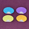 Four oval shaped faces in different colors and pointed teeth sit atop a purple fleece background.