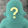 A small teal fleece figure with a question mark instead of a face stands in front of a textured grey background.