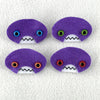 Four oval shaped purple faces with different eye colors and pointed teeth sit atop a white fleece background.